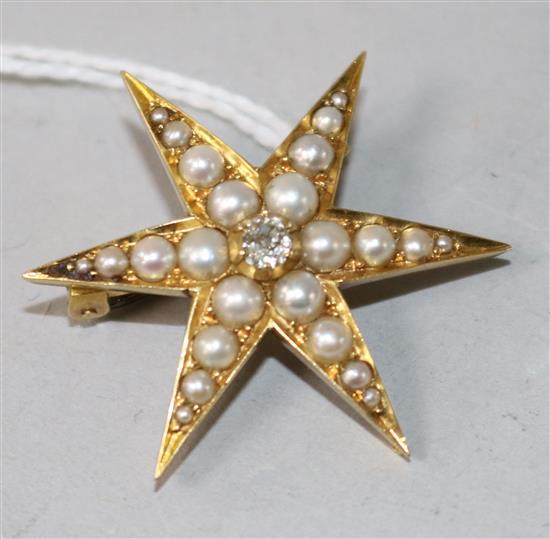 An Edwardian yellow metal, split pearl and diamond set starburst brooch, 30mm.